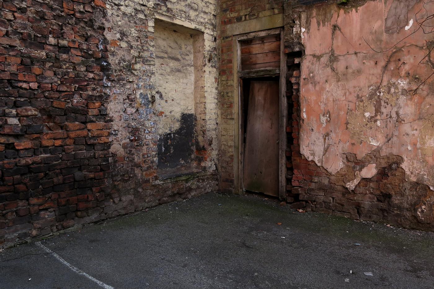 an abandoned building with a worn door in it