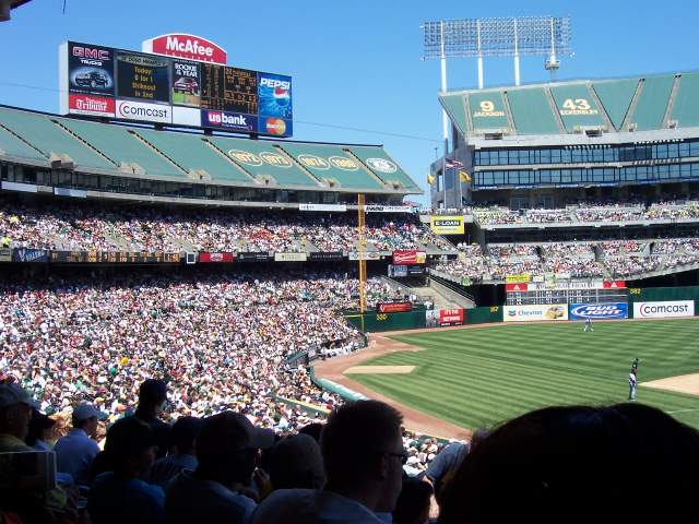 a large group of people in a baseball field watching a game