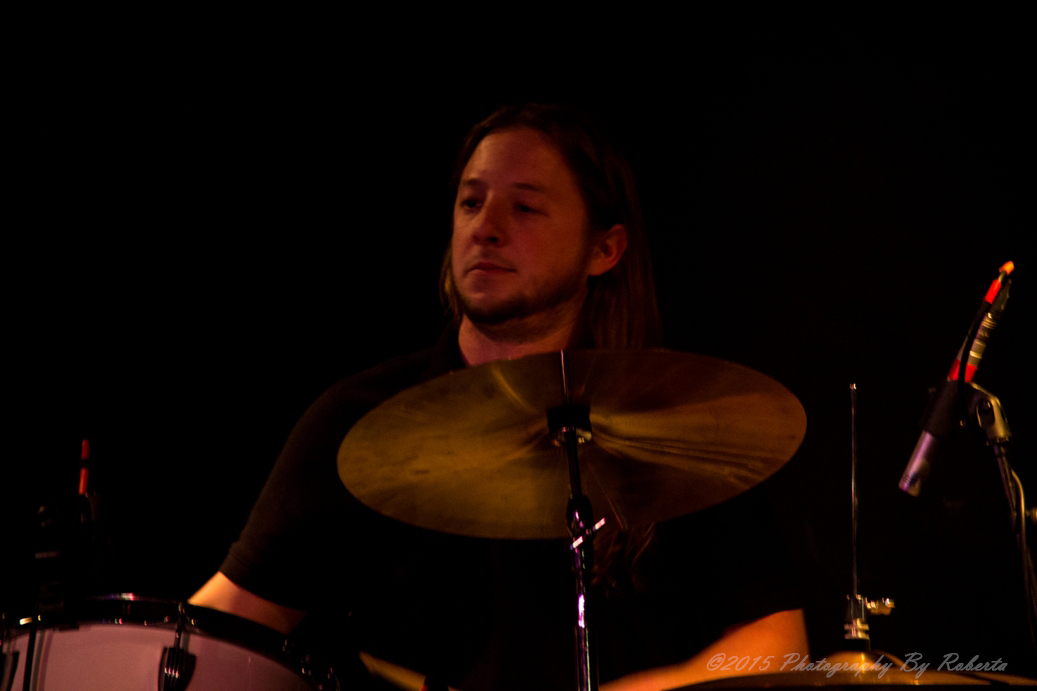 a drummer is playing with his drum set in the dark