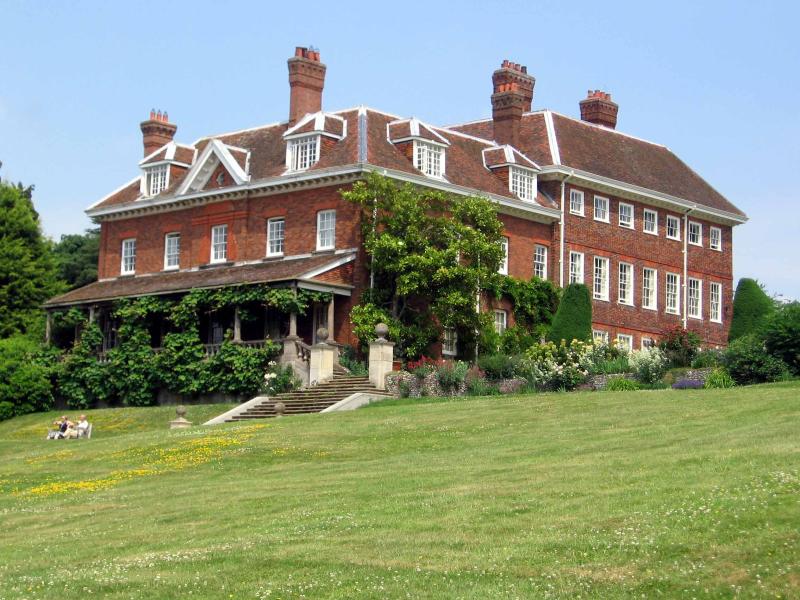 a large brick building sitting on the side of a green field