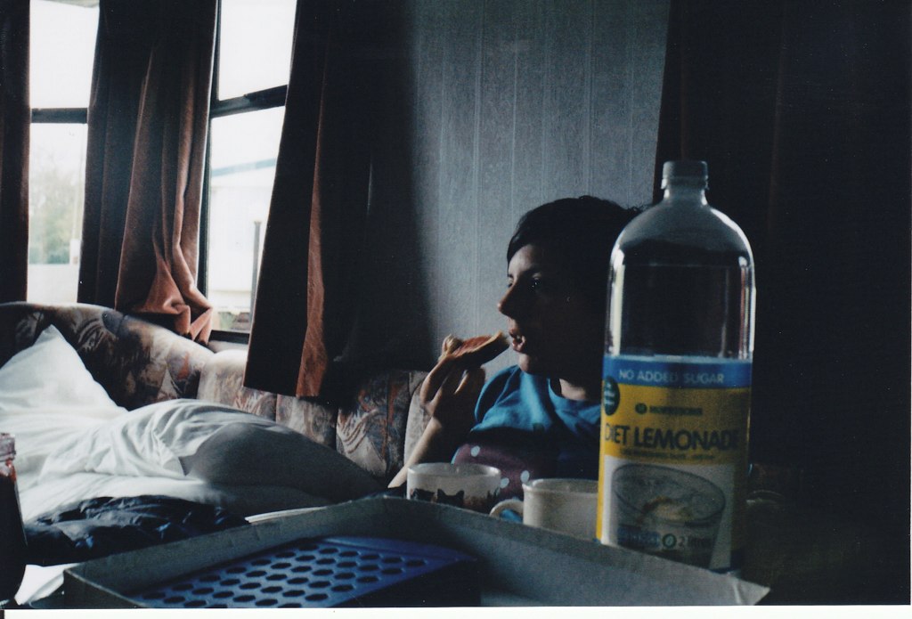 a woman drinking a beverage while on a couch