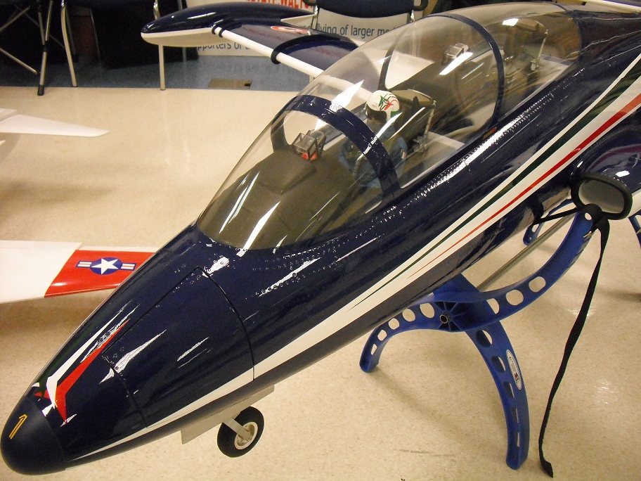 a small model airplane sitting on top of a blue stand
