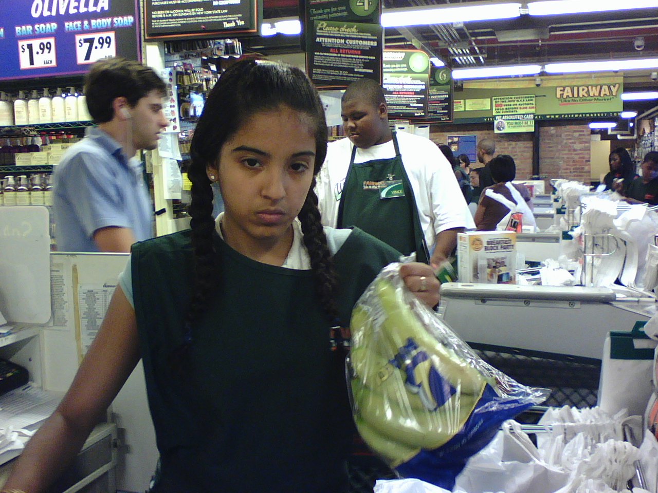 a girl standing in front of some bottles of drinks