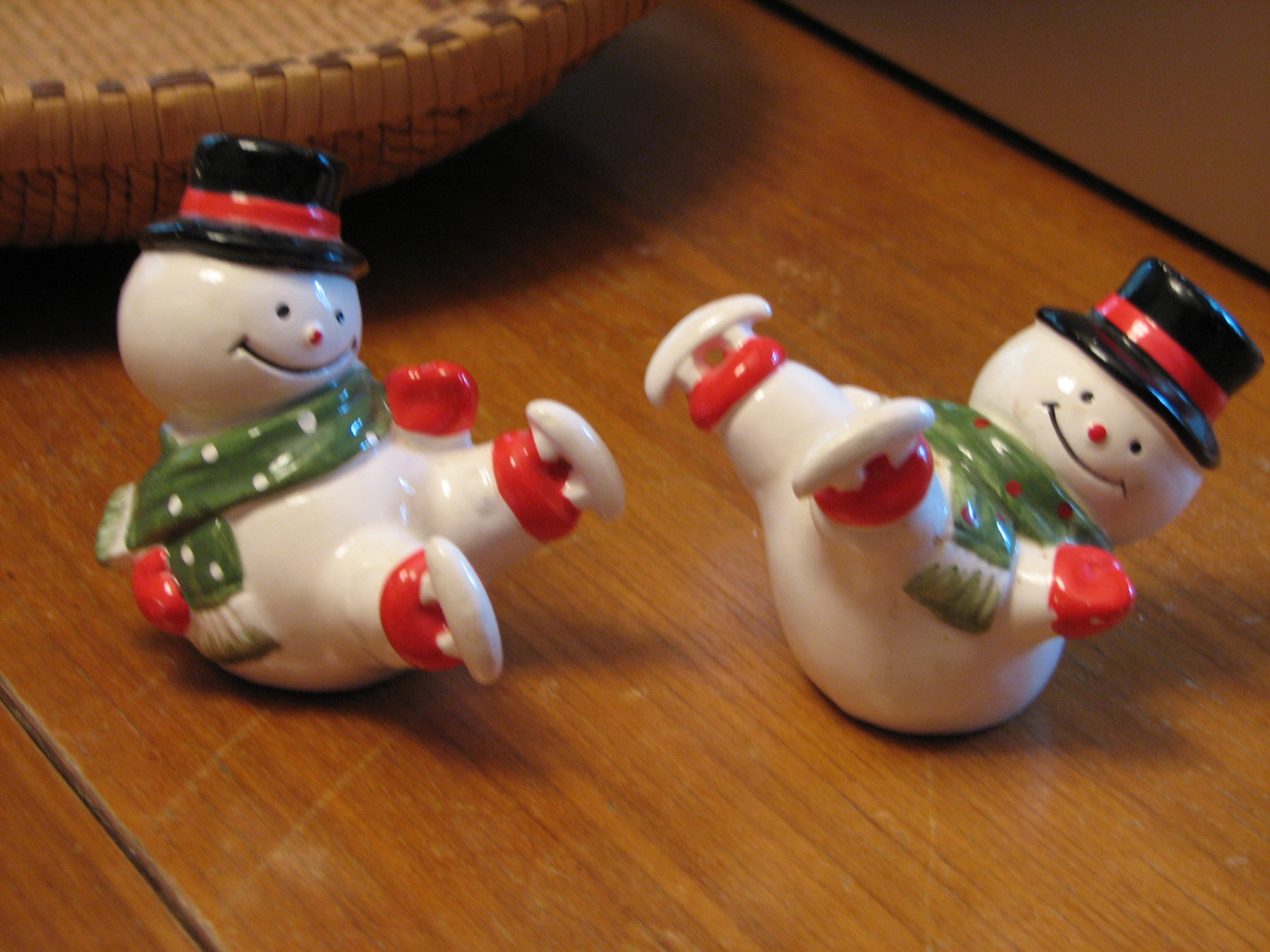 two ceramic snowman salt and pepper shakers with scarfd, hats and scarf around their necks