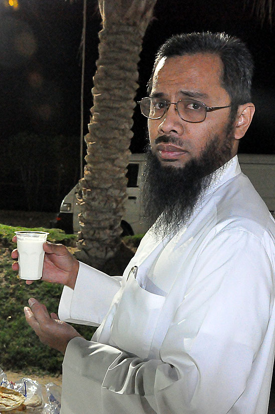 a man with a beard holding a cup and saucer in his hand