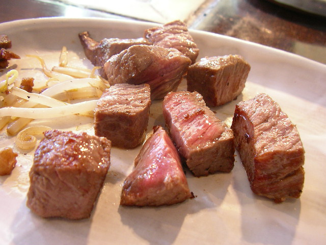 a close up of meat on a plate with onions