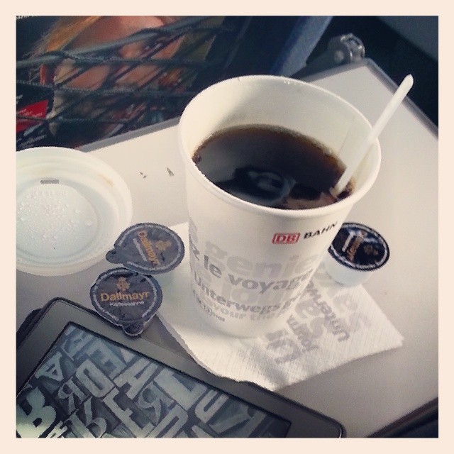 cup of coffee, cell phone and magazine on a table