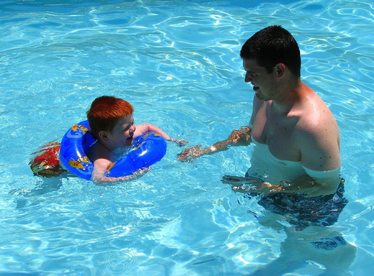 man and child in water with toy life jacket