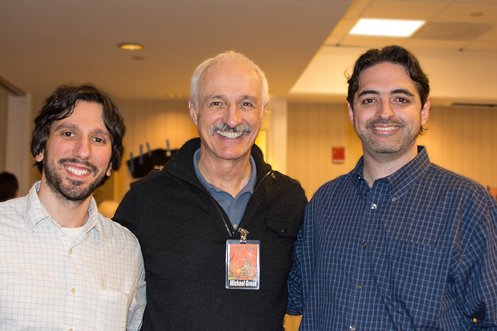 three men smile for the camera as they pose for the camera