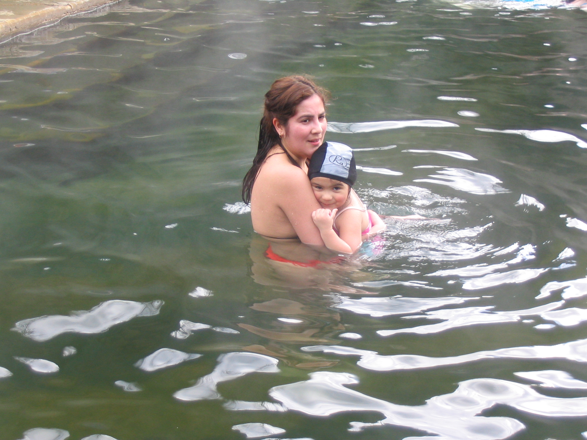an adult with child in a body of water