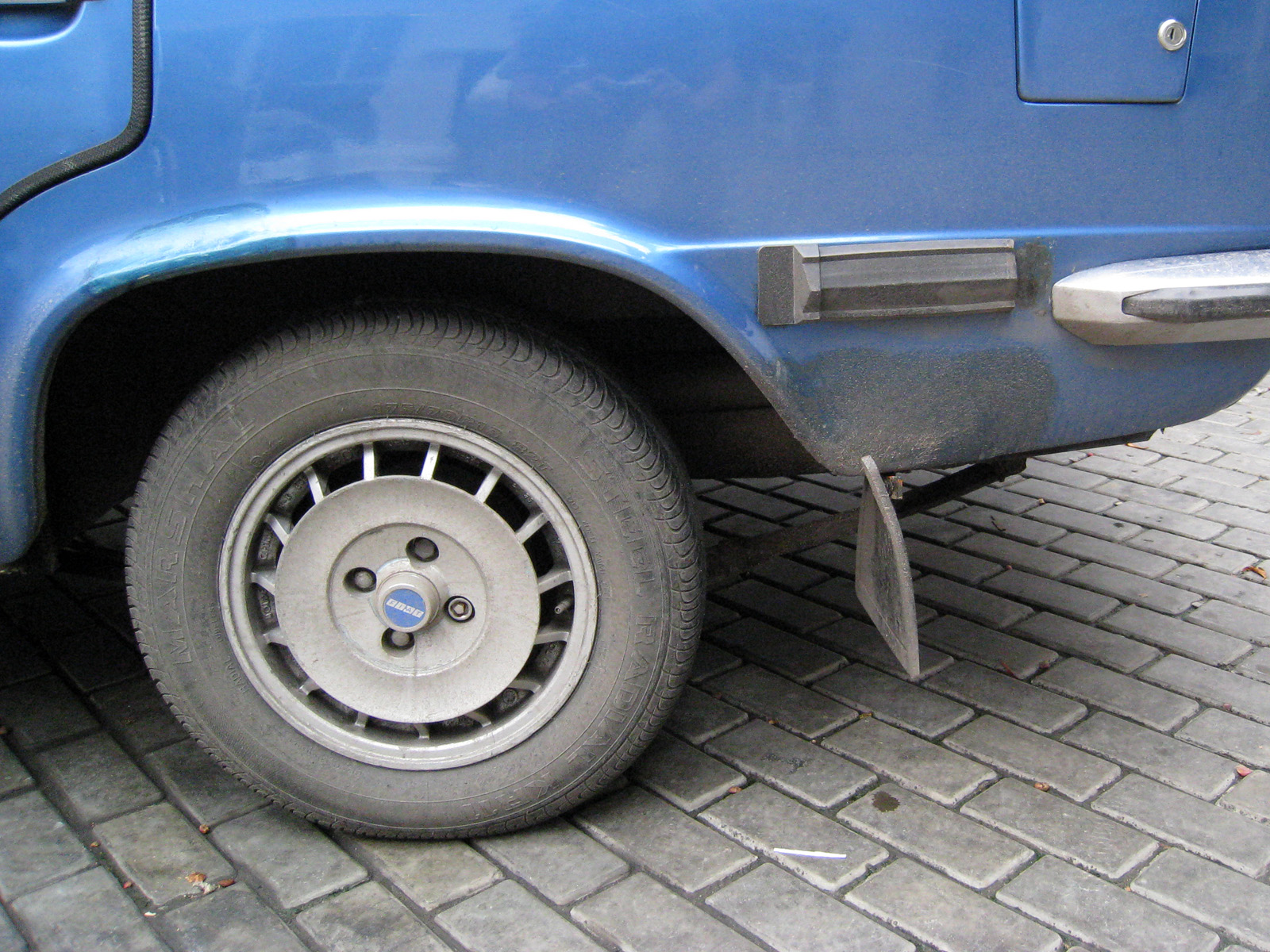 this is the front tire wheel of a blue pick - up truck