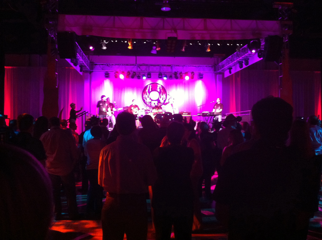 an auditorium filled with people watching and playing musical instruments