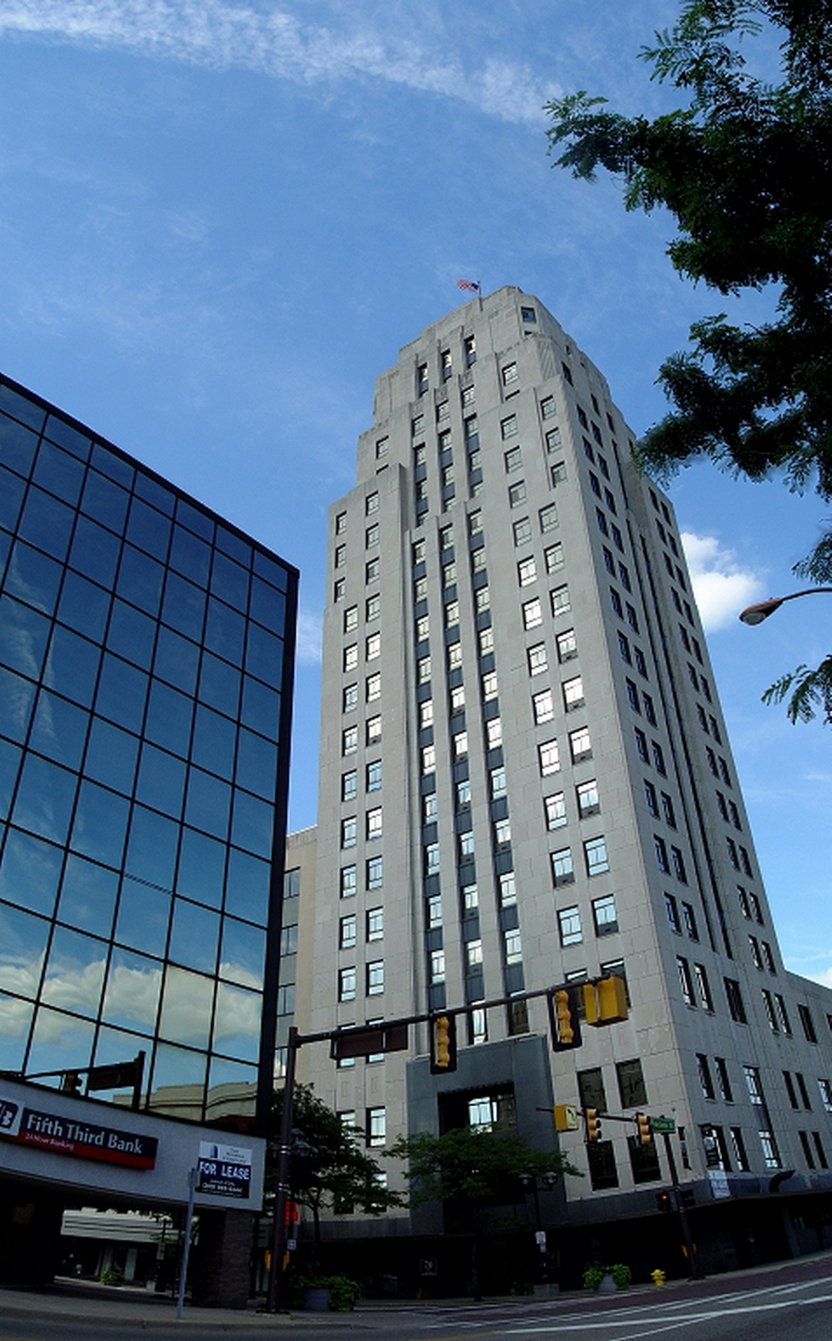 a large skyscr with mirrored windows next to a street