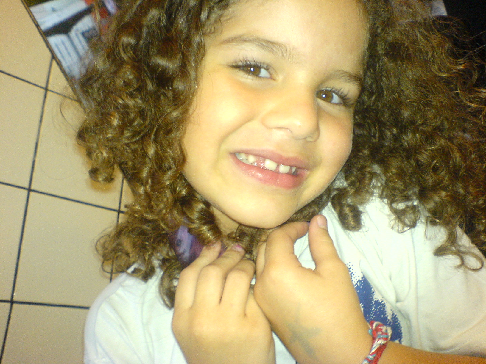 a girl with curly hair smiles and holds her collar