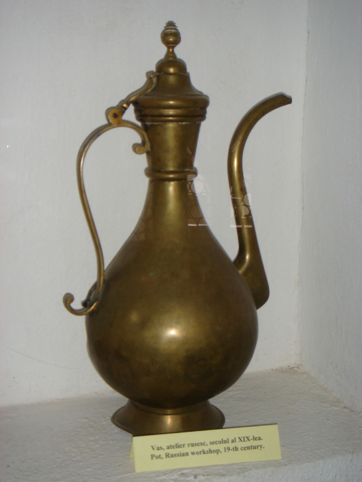 a golden tea pot is shown on a shelf