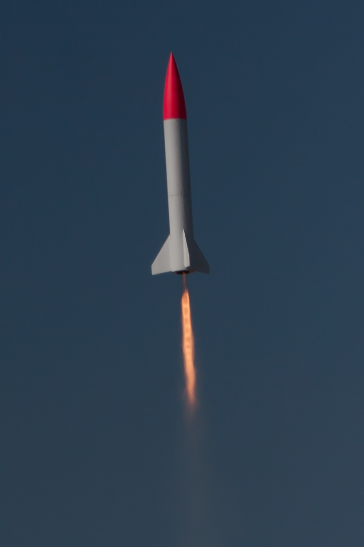 a rocket is being launched through the blue sky