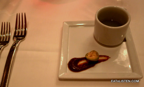 there is a square plate with food on it next to a cup and fork