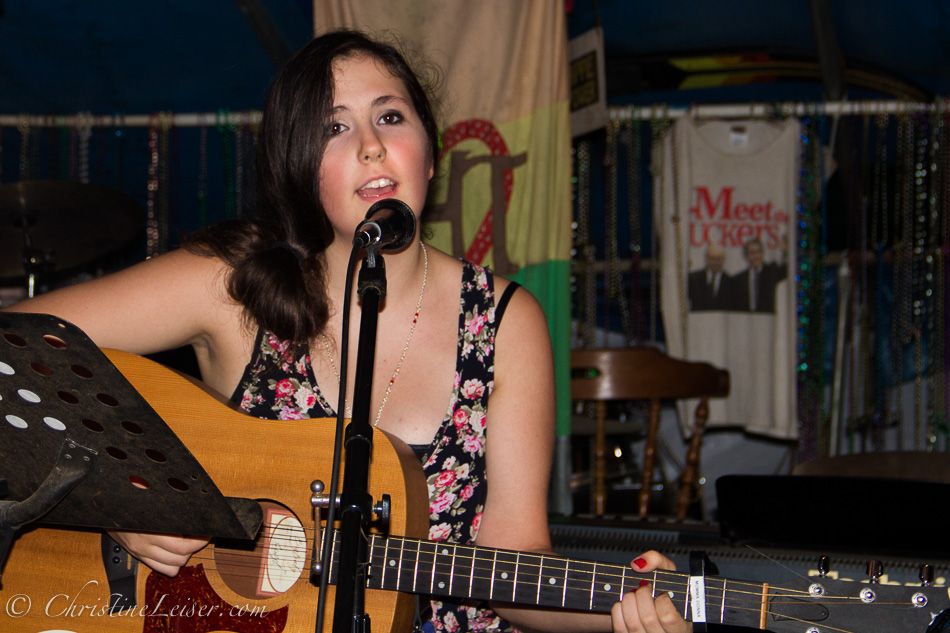 a beautiful young lady playing an acoustic guitar