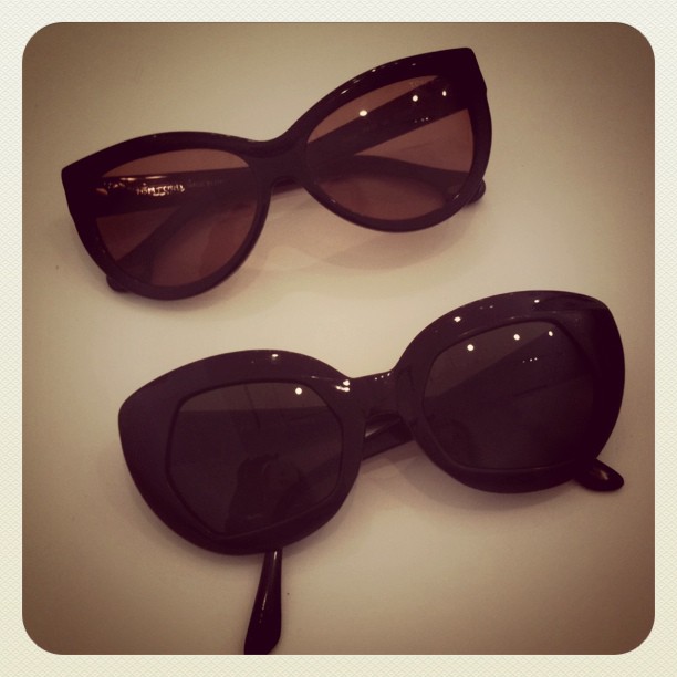 a pair of black sunglasses resting next to each other