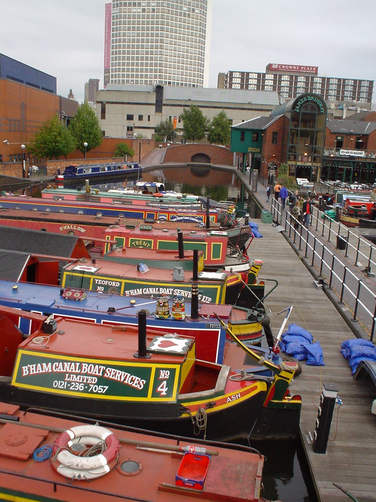 several boats docked on a pier in a city