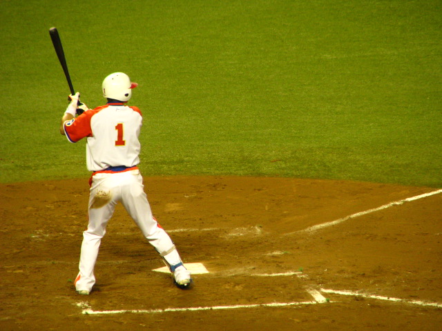 a baseball player holding a bat in his right hand