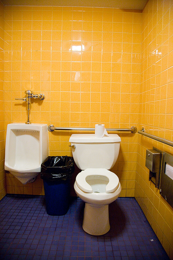 two sinks and a toilet in a yellow bathroom