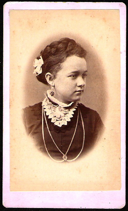 a young woman in black dress with necklaces