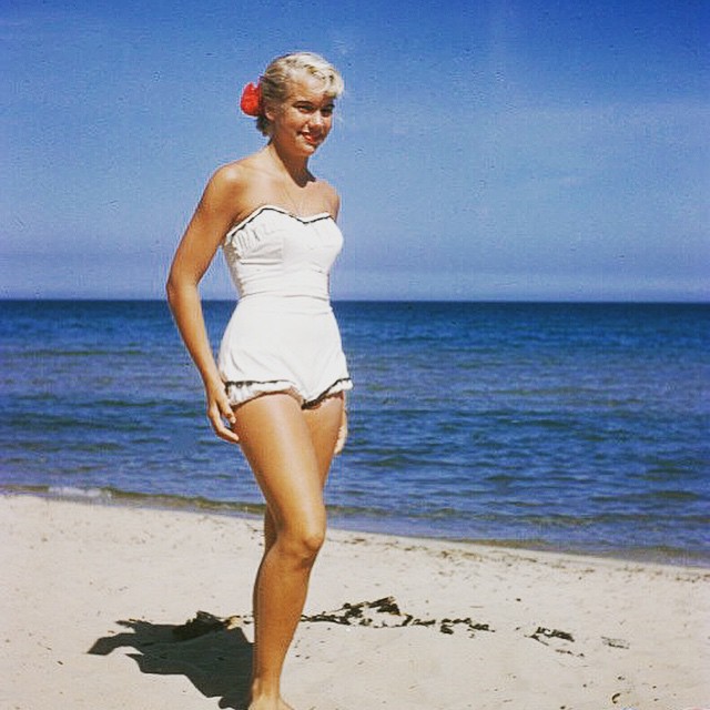 a woman wearing a white bathing suit on the beach