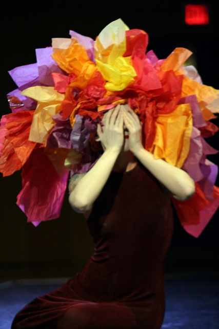 a woman is sitting down and covering her face with her hands