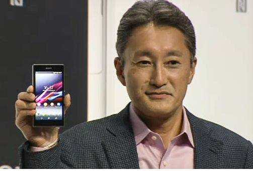 an asian man holds up a cellular phone to show off its new logo