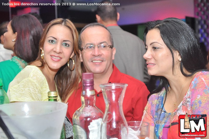 two women and a man are sitting together at a bar