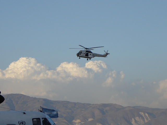 a helicopter is flying in the air above mountains