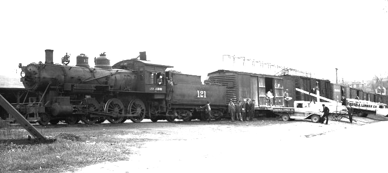 an old train with two trucks near it