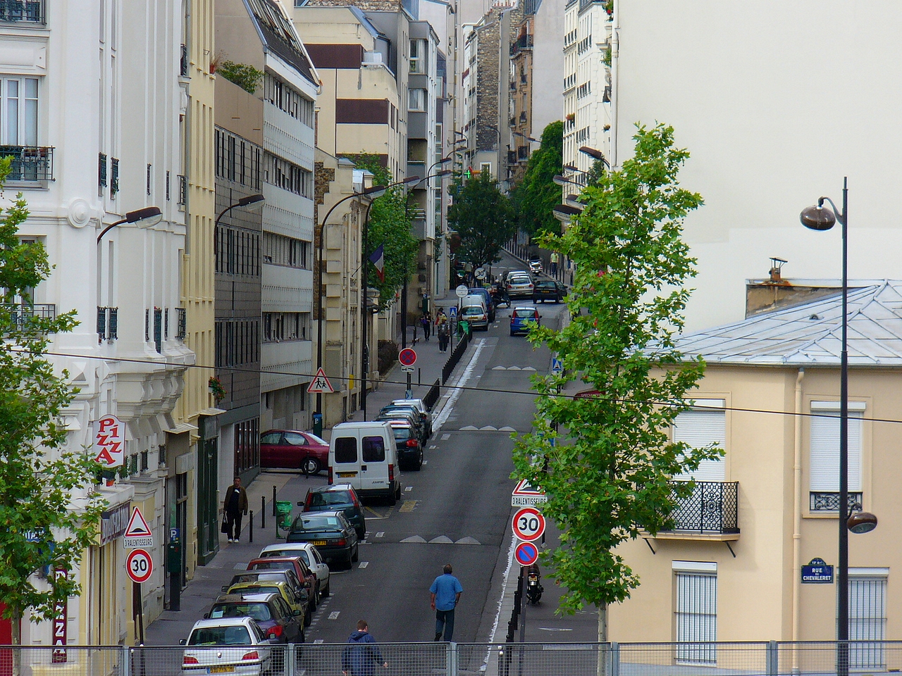 a city street lined with tall buildings and tall trees