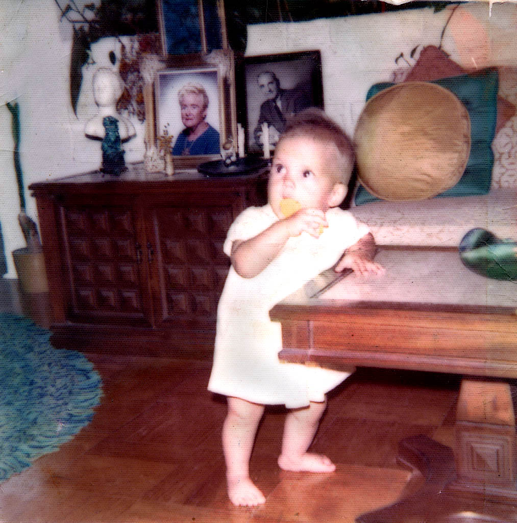 a little girl holding a cup on a wooden table