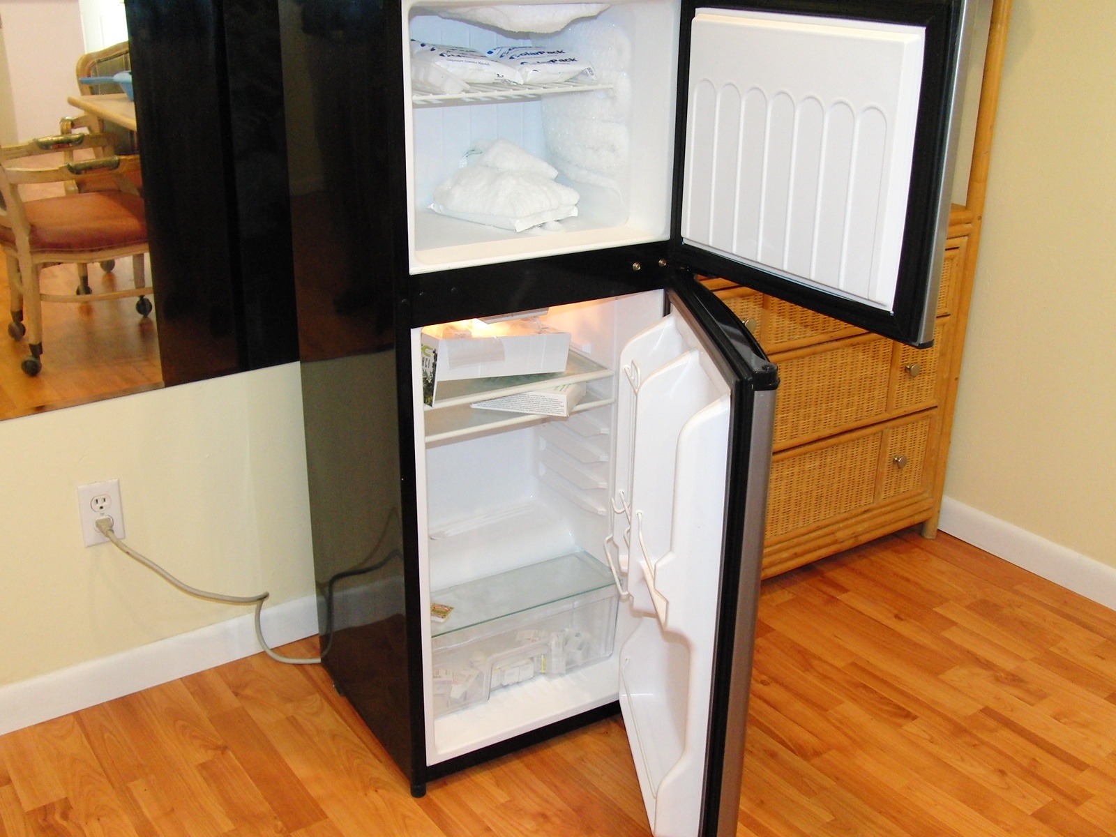 an open refrigerator in the corner of a room