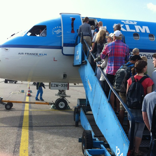 people are walking up to an airplane and getting on