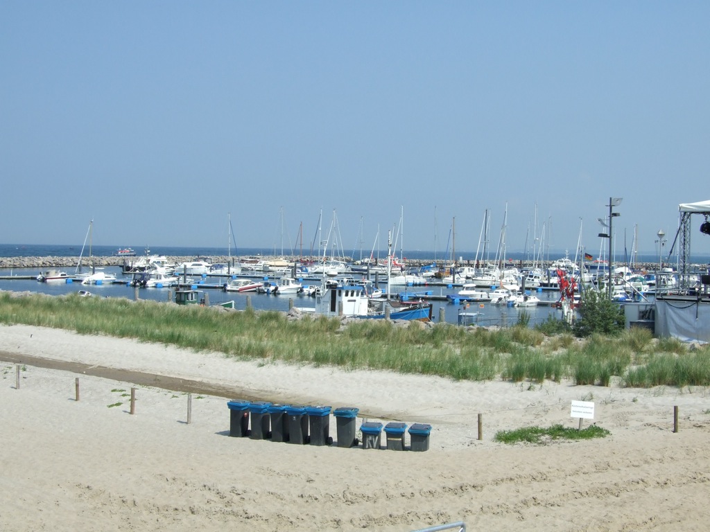 a harbor filled with boats surrounded by grass and sandy sand