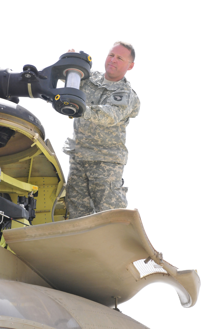 an air force soldier using a scissor to inspect the underside of a plane