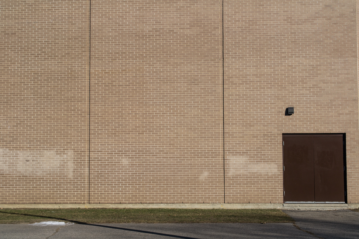 a black and silver fire hydrant next to a brick wall