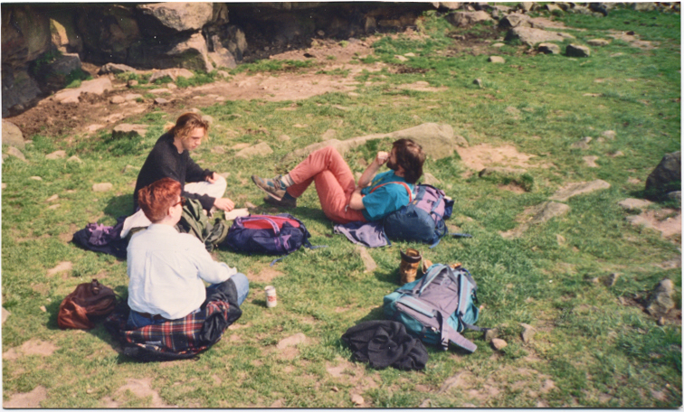 several people on the grass sitting and standing around