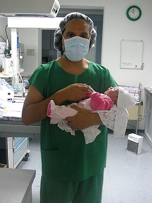a nurse wearing a mask holding a baby