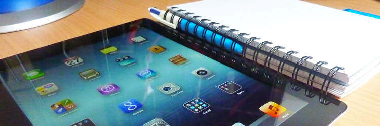 an ipad, a notebook and pen sitting next to each other