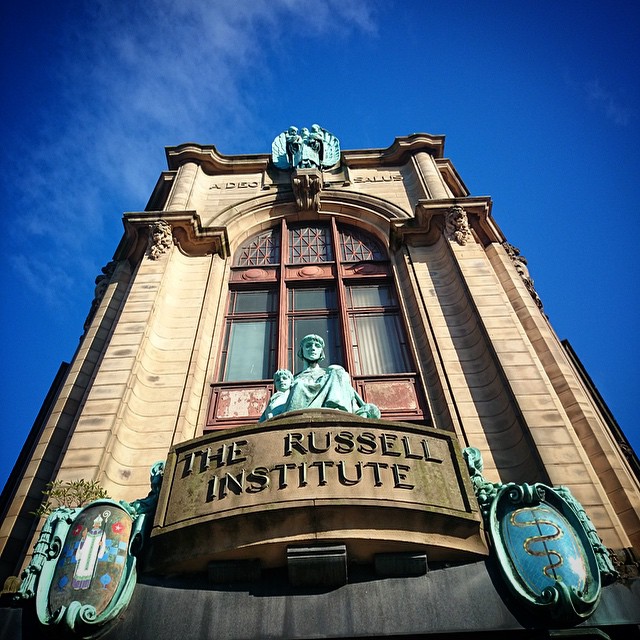 a blue and yellow building with the sign the russell institue