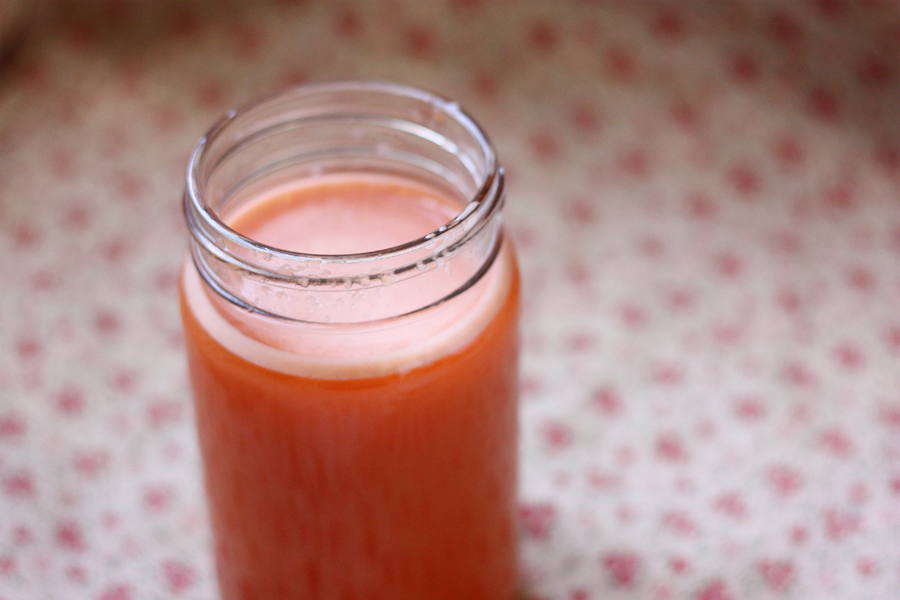 there is a glass jar filled with juice on a table