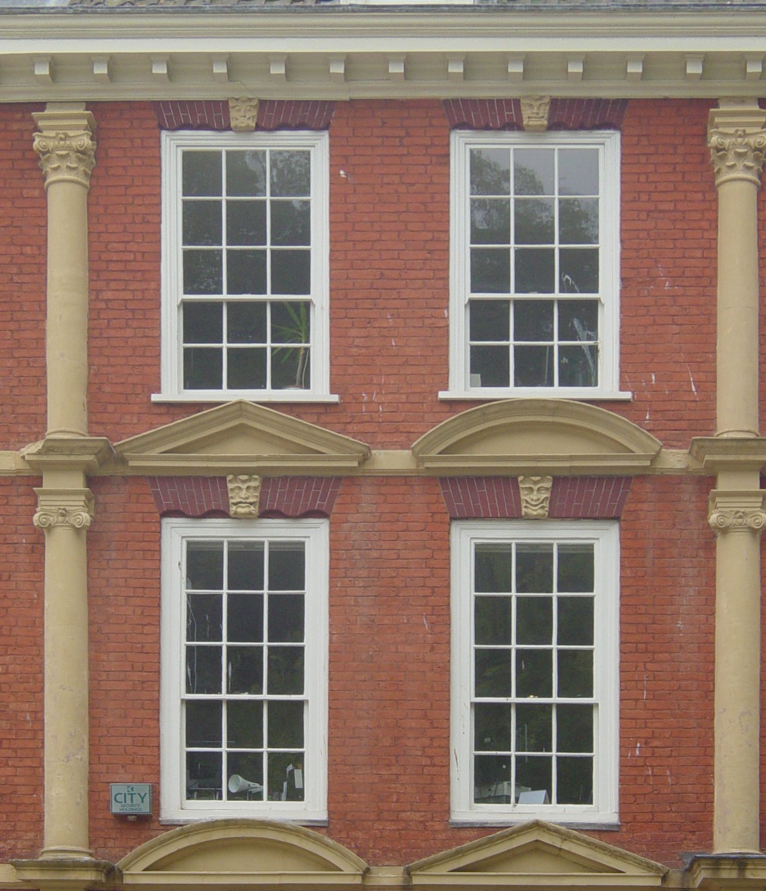 a building that has three windows and a sign near by