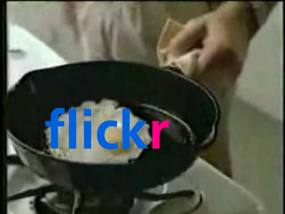 a person is peeling an egg into a frying pan
