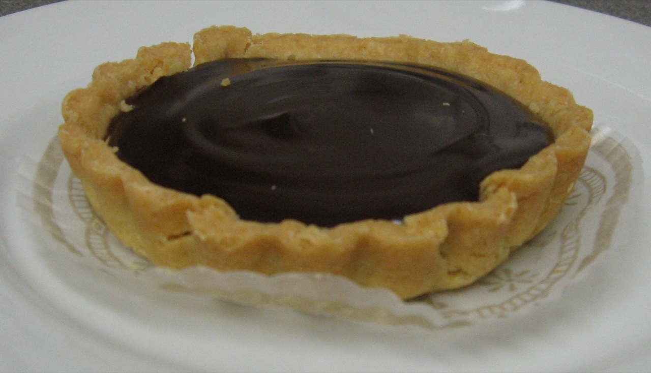 a close up of a chocolate tart on a plate
