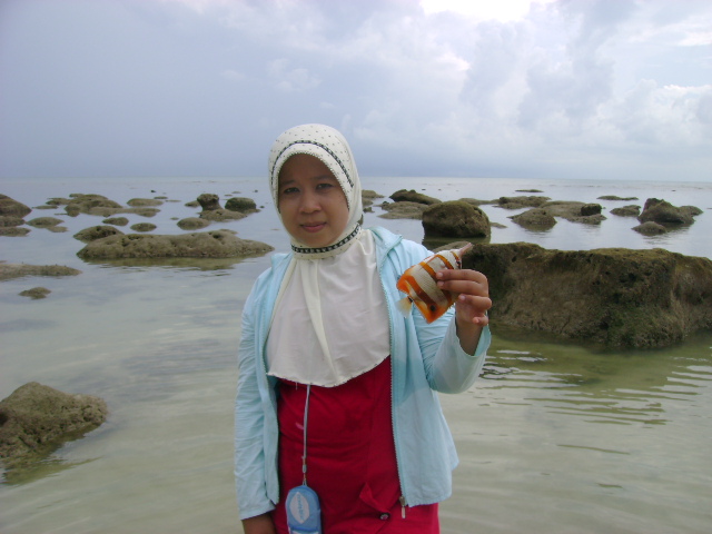 a woman standing in water with rocks behind her