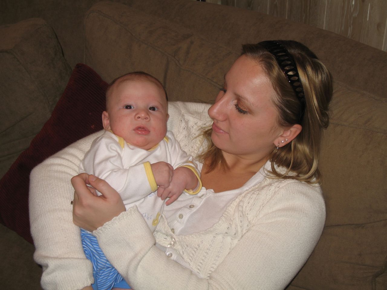 woman holding small child while sitting on couch